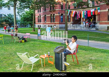 Cambridge Massachusetts, Boston Harvard University Yard campus, adolescente asiatico adolescente ragazzo maschio studente, Weld Hall dormitorio bagagli lettura tablet Foto Stock