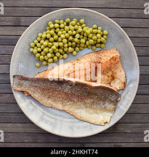 Appetitosi filetti di trote al forno con piselli verdi Foto Stock