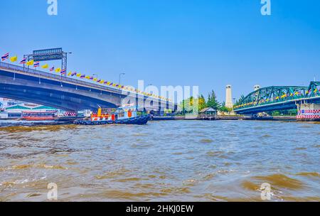 Il veloce viaggio in traghetto sul fiume Chao Phraya sotto il ponte verde Memorial e il ponte Phra Pokklao, situato uno accanto all'altro, Bangkok, Thailandia Foto Stock