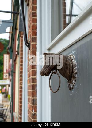 Old Metal Horse Head and Ring attaccato al muro dell'edificio. Foto Stock