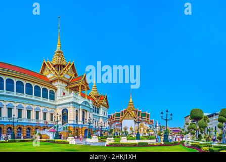 BANGKOK, THAILANDIA - 12 MAGGIO 2019: La vista sulla facciata di Phra Thinang Chakri Maha Prasat attraverso il verde di Rathakit Field, Grand Palace, il 1 maggio Foto Stock