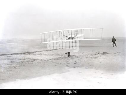 Wilbur Wright sdraiato sulla macchina, Orville Wright che corre a fianco per bilanciare la macchina, durante il primo volo motorizzato, controllato, sostenuto, Kitty Hawk, North Carolina, USA, Wilber Wright, Orville Wright, dicembre 17, 1903 Foto Stock