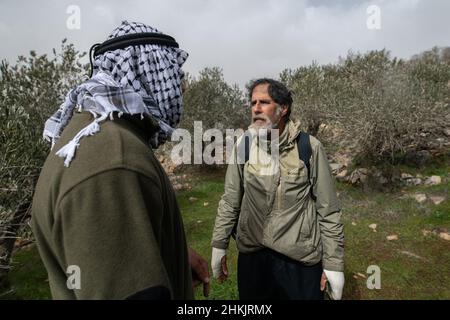 Burin, Palestina. 04th Feb 2022. Il giovane palestinese parla con Arik Ascherman dell’organizzazione israeliana per i diritti umani “Rabbis for Human Rights”. Secondo lui, le sue mani sono fasciate per proteggersi dai coloni ebrei. Centinaia di attivisti di pace israeliani e palestinesi avevano piantato ulivi nel villaggio palestinese di Burin, sotto l'avamposto illegale ebraico di Givát Ronen. Due settimane prima dell'evento, un gruppo di attivisti di pace ebrei arrivati per la piantagione di olive sono stati violentemente attaccati dai giovani di Givát Ronen. Oggi, le forze dell'IDF si erano separate tra gli attivisti e. Foto Stock