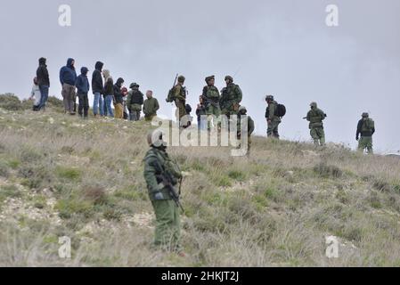 Burin, Palestina. 04th Feb 2022. Soldati dell'IDF che impediscono ai coloni ebrei di raggiungere gli attivisti. Centinaia di attivisti di pace israeliani e palestinesi avevano piantato ulivi nel villaggio palestinese di Burin, sotto l'avamposto illegale ebraico di Givát Ronen. Due settimane prima dell'evento, un gruppo di attivisti di pace ebrei arrivati per la piantagione di olive sono stati violentemente attaccati dai giovani di Givát Ronen. Oggi, le forze dell'IDF si erano separate tra gli attivisti e i coloni. Un attivista israeliano è stato arrestato durante l'evento. Burin, Palestina. Feb 04th 2022. (Foto di Matan Golan/S. Foto Stock