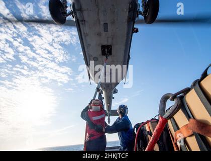 220202-N-PH222-1630 SOUTH CHINA SEA (FEB 2, 2022) i marinai partecipano ad un rifornimento verticale con un elicottero MH-60s Sea Hawk, assegnato ai "Blackjack" di Helicopter Sea Combat Squadron (HSC) 21, dal ponte di volo a bordo della nave da combattimento litoranea variante Independence USS Charleston (LCS 18). Charleston, parte di Destroyer Squadron (DESRON) 7, è in fase di implementazione rotazionale nell'area operativa della flotta USA 7th per migliorare l'interoperabilità con i partner e fungere da forza di risposta pronta a supporto di una regione indopacifica libera e aperta. (STATI UNITI Foto Navy di Mass Communication Speci Foto Stock