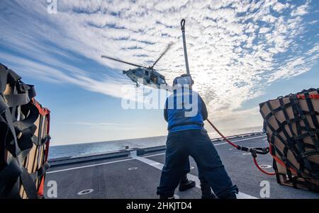 220202-N-PH222-1505 SOUTH CHINA SEA (FEB 2, 2022) i marinai partecipano ad un rifornimento verticale con un elicottero MH-60s Sea Hawk, assegnato ai "Blackjack" di Helicopter Sea Combat Squadron (HSC) 21, dal ponte di volo a bordo della nave da combattimento litoranea variante Independence USS Charleston (LCS 18). Charleston, parte di Destroyer Squadron (DESRON) 7, è in fase di implementazione rotazionale nell'area operativa della flotta USA 7th per migliorare l'interoperabilità con i partner e fungere da forza di risposta pronta a supporto di una regione indopacifica libera e aperta. (STATI UNITI Foto Navy di Mass Communication Speci Foto Stock