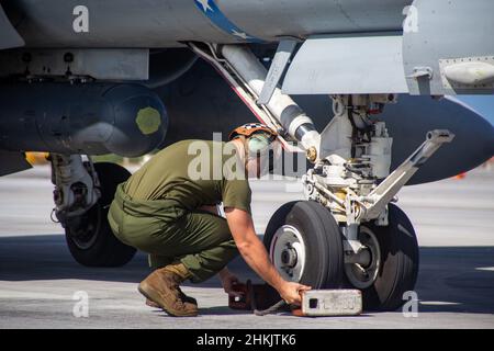 CPL del corpo marino degli Stati Uniti. Cameron Sousa, un meccanico di linea con attacco di caccia alla Marina Squadron 112, mette a galla sotto un F/A-18C Hornet Aircraft alla Andersen Air Force base, Guam, 26 gennaio 2022. I Marines con VMFA-112 stanno effettuando un addestramento a livello di unità presso la base dell'aeronautica di Andersen come parte di un programma di trasferimento di addestramento dell'aviazione. (STATI UNITI Foto del corpo marino di Sgt. Booker T. Thomas III) Foto Stock