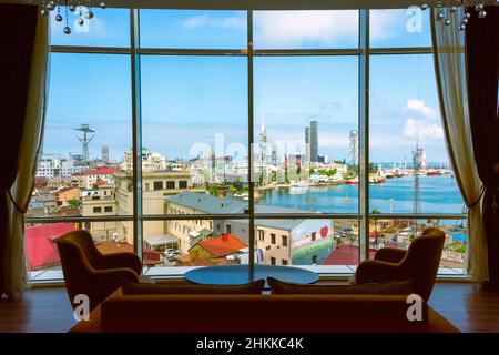 Vista della città lungo la costa del Mar Caspio attraverso le finestre, Batumi Technological University Tower con una ruota di ferro costruita nella facciata, Foto Stock