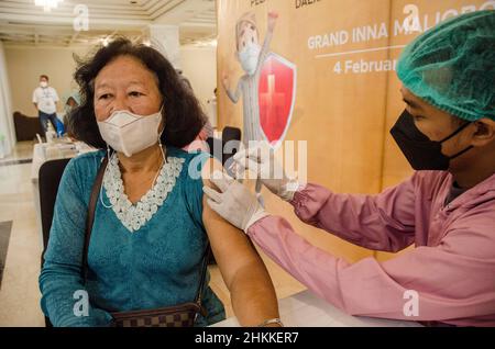 Yogyakarta, Indonesia. 4th Feb 2022. Un operatore sanitario inocula una donna con una dose di richiamo del vaccino COVID-19 in Yogyakarta, Indonesia, 4 febbraio 2022. Indonesia Venerdì ha confermato 32.211 nuovi casi COVID-19, portando il suo numero di infezioni a 4.446.694, ha detto il Ministero della Sanità del paese. Credit: Agung Supriyanto/Xinhua/Alamy Live News Foto Stock