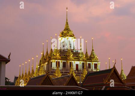 Cima della vecchia pagoda di Loha Prasat di Wat Ratchanatdaram Woravihara tempio buddista contro il cielo della sera. Bangkok, Tailandia Foto Stock