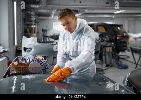 Meccanico in carrozzeria auto verniciata con levigatura uniforme Foto Stock