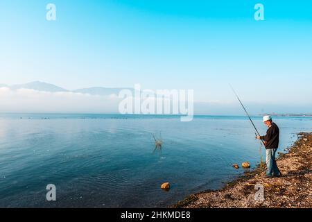 Vista di un pescatore che pesca sul lago Sapanca. Il lago Sapanca è un lago d'acqua dolce in Turchia. Stagione autunnale. Foto Stock