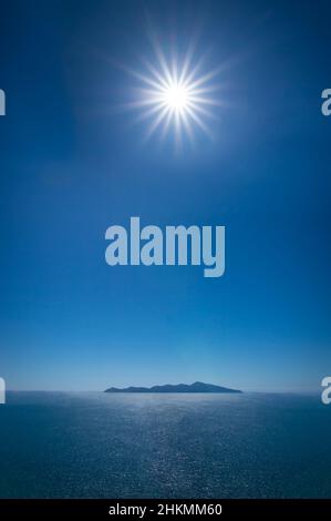 Il sole splende direttamente sopra l'isola di Kapiti, Nuova Zelanda Foto Stock