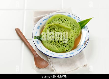 Serabi o Surabi, indonesiano tradizionale Pancanake forma Giavanese, Indonesia. Fatto di farina, farina di riso e latte di cocco. Servito con Palm Sung addensato Foto Stock