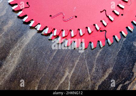 Primo piano due lame di ricambio rosse per sega circolare su superficie in legno, produzione di mobili, fuoco selettivo Foto Stock