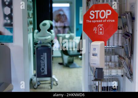 Berlino, Germania. 05th Feb 2022. Al salone dei capelli Mac a Wannsee, c'è un cartello che chiede alle persone di disinfettare le mani. In vista dell'ondata di Omikron, il Senato di Berlino ha adottato alcune nuove regole di Corona. Il regolamento è in vigore dal 05.02.2022. Credit: Carsten Koall/dpa/Alamy Live News Foto Stock