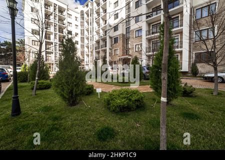 Un ampio balcone curvo di un edificio a più piani con ringhiere in ferro battuto nero di metallo con motivi. Il balcone offre una vista sulle case della Foto Stock