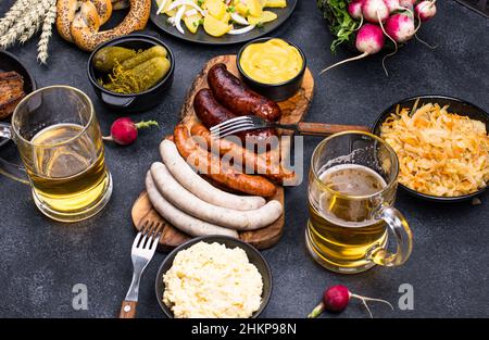 Piatti Oktoberfest con birra, pretzel e salsiccia Foto Stock