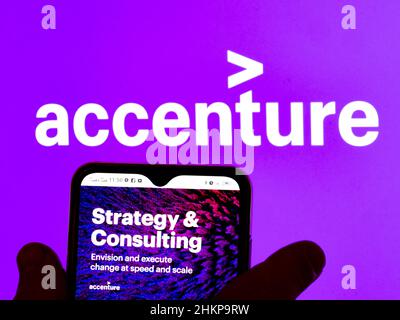 In questa illustrazione, il logo Accenture Strategy & Consulting viene visualizzato sullo schermo di uno smartphone con il logo Accenture plc sullo sfondo. Foto Stock