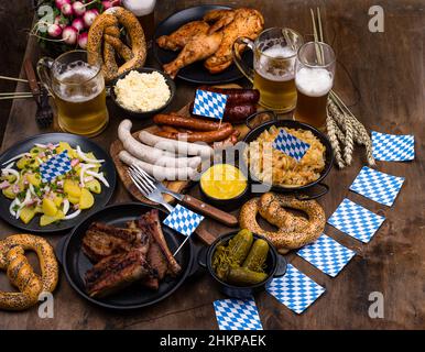 Piatti Oktoberfest con birra, pretzel e salsiccia Foto Stock