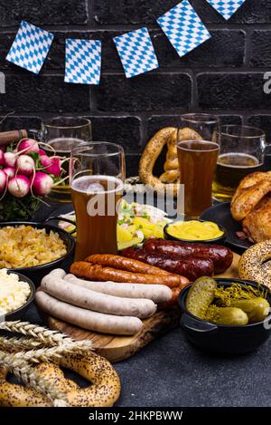 Piatti Oktoberfest con birra, pretzel e salsiccia Foto Stock