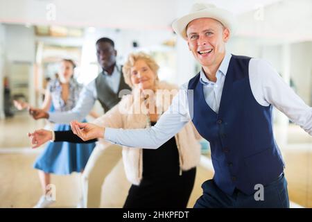 Gruppo di danzatori di età diversi che preparano prestazioni di oscillazione Foto Stock