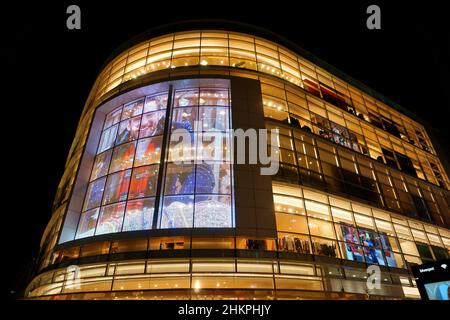 Edificio in vetro illuminato moderno con schermo pubblicitario del grande magazzino di abbigliamento Peek & Cloppenburg a Düsseldorf/Germania. Foto Stock