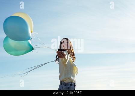 Bella giovane donna che si diverte con palloni colorati Foto Stock