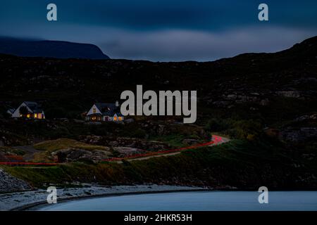 Percorsi leggeri su una strada costiera nelle Highlands della Scozia al tramonto Foto Stock