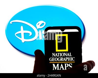 In questa illustrazione, il logo National Geographic Maps viene visualizzato sullo schermo di uno smartphone con il logo Disney sullo sfondo. Foto Stock