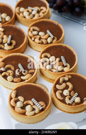 Torta deliziosa con nocciole, caramello dolce su tavola bianca. Foto Stock