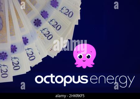 Fornitori di elettricità e gas OCTOPUS LOGO ENERGIA visto su sfondo sfocato e lampadina a risparmio energetico di fronte. Regno Unito, Stafford, 18 dicembre 2022 Foto Stock