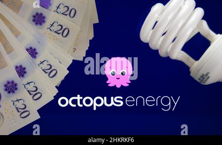 Fornitori di elettricità e gas OCTOPUS LOGO ENERGIA visto su sfondo sfocato e lampadina a risparmio energetico di fronte. Regno Unito, Stafford, 18 dicembre 2022 Foto Stock