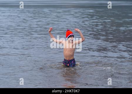 OLDENZAAL, OLANDA - 1 GENNAIO 2020: Il ragazzo mette le braccia in aria dopo la sua immersione tradizionale di nuovo anno (nieuwjaarsduik) il primo giorno del Foto Stock