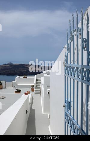 Santorini, Grecia - 7 maggio 2021 : porta e scalini che conducono ad un edificio residenziale con una splendida vista sul Mar Egeo e sul vulcano di Santor Foto Stock