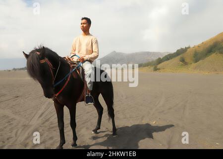 Cavalieri vicino al Monte bromo. Un uomo a cavallo in bromo, Giava orientale, Indonesia Foto Stock