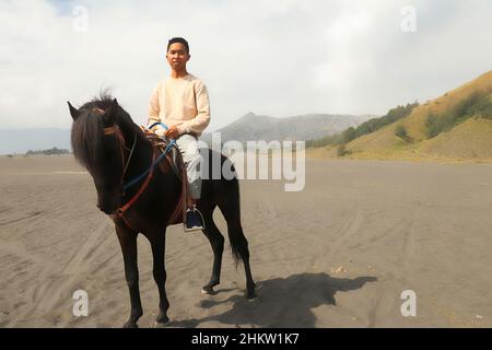 Cavalieri vicino al Monte bromo. Un uomo a cavallo in bromo, Giava orientale, Indonesia Foto Stock