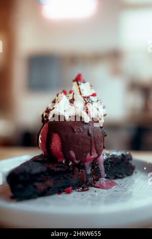 Primo piano di un ricco brownie al cioccolato con gelato alla fragola Foto Stock