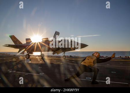 Un Aviation Boatswainʼs Mate (Handling), pranza un F-35B Lightning II, assegnato a Marine Fighter Attack Squadron (VMFA) 122, da USS Makin Island durante le operazioni di addestramento di routine, nell'Oceano Pacifico dal 2 febbraio 2022. In preparazione del loro prossimo dispiegamento con la 13th Marine Expeditionary Unit (MEU) e Makin Island Amphibious Ready Group, F-35Bs da VMFA-122 volò a bordo dell'isola di Makin mentre era in corso con elementi del MEU 13th imbarcato. (STATI UNITI Foto del corpo marino di CPL. Cotogna bisarda) Foto Stock