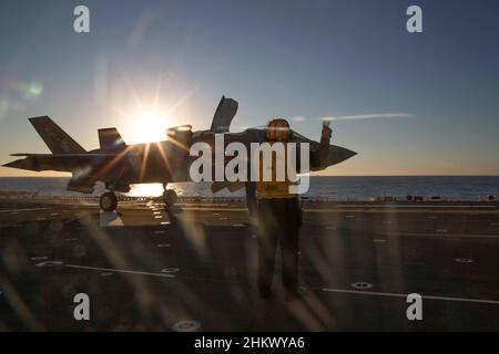 Un Aviation Boatswainʼs Mate (Handling), dirige un F-35B Lightning II, assegnato a Marine Fighter Attack Squadron (VMFA) 122, che si prepara a lanciare dall'USS Makin Island durante le operazioni di formazione di routine, nell'Oceano Pacifico dal 2 febbraio 2022. In preparazione del loro prossimo dispiegamento con la 13th Marine Expeditionary Unit (MEU) e Makin Island Amphibious Ready Group, F-35Bs da VMFA-122 volò a bordo di Makin Island mentre era in corso con elementi del MEU 13th imbarcato. (STATI UNITI Foto del corpo marino di CPL. Cotogna bisarda) Foto Stock