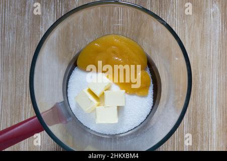 Ingredienti per la torta al miele: Miele, burro, zucchero prima di cuocere a bagnomaria su sfondo ligneo Foto Stock
