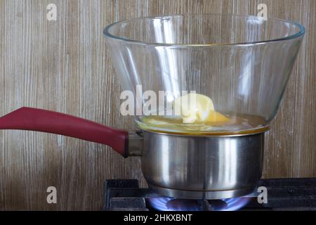 Ingredienti per la torta al miele: Miele, burro, zucchero che cucinano sulla bagnomaria su sfondo di legno Foto Stock