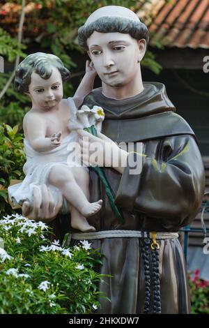 Statua di un monaco cristiano con bambina nella chiesa di Santa Cruz costruita in portoghese presso il fiume Chao Phraya a Thonburi, Bangkok, Thailandia Foto Stock