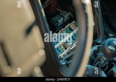 Cattivo stato del portafusibili in una vecchia auto d'epoca. Alloggiamento bruciato di un fusibile tipico in una scatola fusibili nella console centrale. Foto Stock