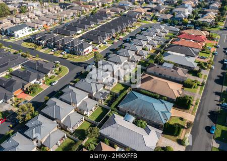 Vista aerea di file di case in stile 'cookie cutter' costruite durante il 2010s nella periferia esterna di Sydney, Australia. Foto Stock