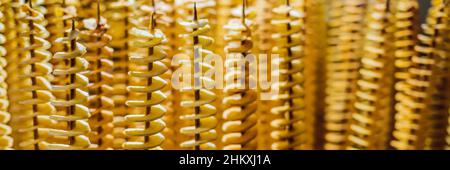 Spirale di patate fritte, su bastoni di legno a spirale. La vendita di prodotti alimentari al mercato. Malsana alimenti fritti. Cucina di strada, una spirale di patate fritte su un bastone Foto Stock