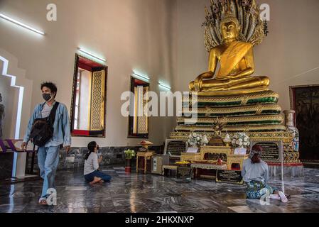 Bangkok, Tailandia. 05th Feb 2022. I turisti hanno visto pregare di fronte alla statua del Buddha al Tempio del Buddha reclinato. Il governo thailandese ha ripreso il programma 'Test and Go' il 1 febbraio, 2022 per accogliere visitatori completamente vaccinati provenienti da tutti i paesi con misure supplementari di controllo delle malattie volte a promuovere l'industria del turismo e la sua economia in mezzo alla diffusione in corso della variante Omicron del covid-19. (Foto di Peerapon Boonyakiat/SOPA Images/Sipa USA) Credit: Sipa USA/Alamy Live News Foto Stock