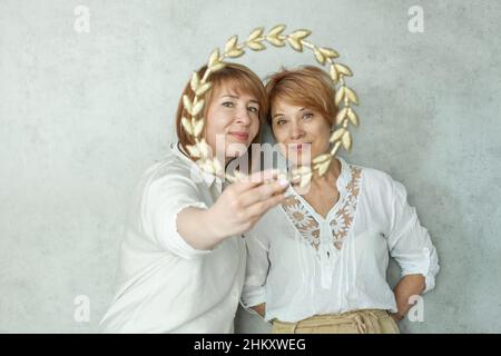 Due donne mature che guardano la macchina fotografica e sorridono Foto Stock