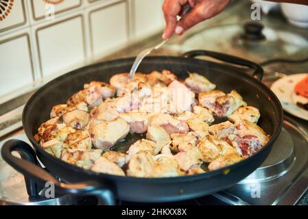Preparazione del pollo all'aglio nella padella Foto Stock