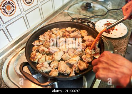 Preparazione del pollo all'aglio nella padella Foto Stock